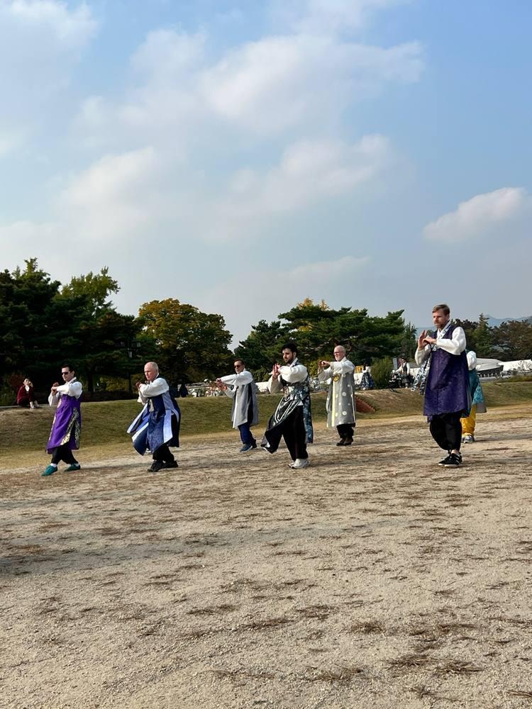 Practicing forms in hanbok with mountain backdrop